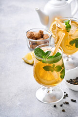 Traditional iced tea with lemon and ice in tall glasses on marble table background Iced tea with lemon. Selective focus. Refreshment cold summer drink.