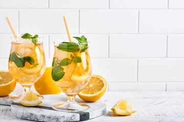 Traditional iced tea with lemon and ice in tall glasses on marble table background Iced tea with lemon. Selective focus. Refreshment cold summer drink.