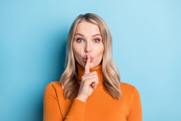 Photo of funny charming young woman dressed orange pullover finger mouth asking shut up isolated...