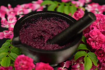Homemade rose petals jam in mortar. Raw jam made of rose petals, sugar and lemon juice, without...