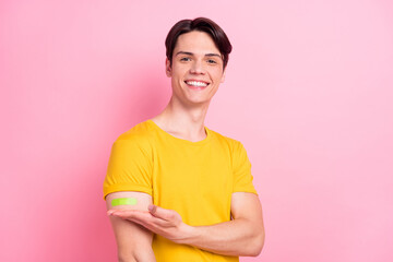 Photo of cheerful guy hand presenting vaccination injection result wear yellow t-shirt isolated on...