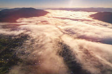Aerial top view landscape Mountain with visible silhouettes forest tree through morning colorful fog sunrise