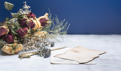 Spring bouquet of dried flowers with Steel letter opener and Empty Blank Paper, on vintage background.