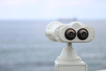 White binocular in front of the sea