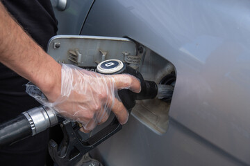 a man equipped with a glove, refueling a diesel tank