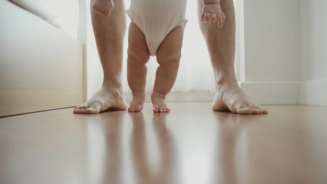 Asian Toddler enjoying the first steps with dad.