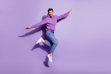 Full length body size view of attractive glad cheerful guy jumping having fun fooling isolated over purple violet color background