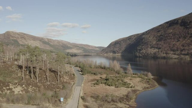 4K drone rising shot of Loch Dughaill with the view back town to Lochcarron. Located in the Highlands of Scotland.