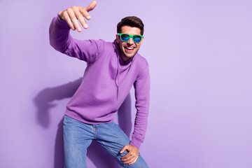 Portrait of attractive cheerful cool confident guy dancing having fun chill isolated over purple...