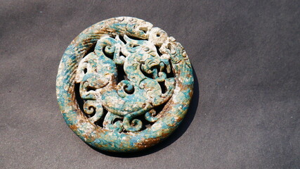 Fototapeta na wymiar Turqouise jade pendant engraved with a dragon inside a twin dragon bracelet, 6.8 cm in diameter, 0.5 cm thick, 51 grams in weight this jade pendants were buried in the ground for hundreds of years 