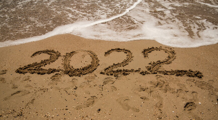 the inscription 2022 on the wet sea sand