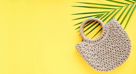 Summer women's straw bag and tropical green palm leaf on yellow background. Travel concept. Natural, organic, eco friendly, zero waste, plastic free concept. Mock up. Flat lay, top view, copy space