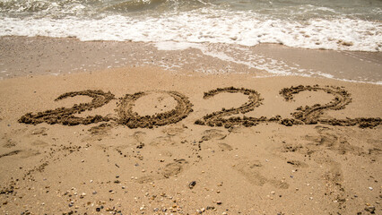 the inscription 2022 on the wet sea sand