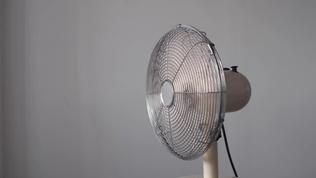 Air fan turning from side to side blowing wind.  Electric fan cooling High heat Temperature Ventilator Cooling the room. Electric Fan-Cooler wings speeding up until getting to  full speed. concept