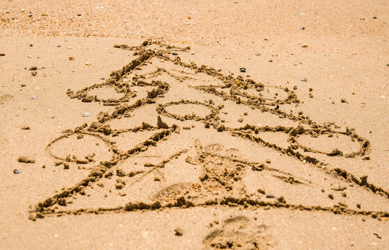 a Christmas tree is painted on the sea sand