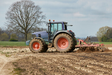 Obraz premium Tractor plowing in a field Springtime