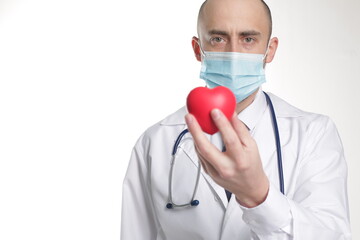 Young doctor wearing a mask with stethoscope and red heart isolated over white background