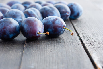 plums on black wood table, front view