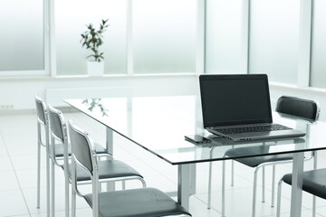 Fototapeta na wymiar Laptop on glass table in spacious office space