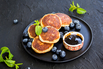 A healthy breakfast of cheese pancakes, berries, and honey. Creative atmospheric decoration