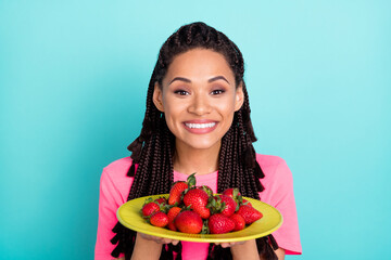 Photo of cheerful adorable girl hold dish strawberry wear pink t-shirt isolated on blue color...