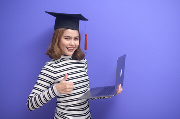 Portrait of young woman graduated over blue background
