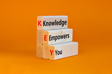 KEY, knowledge empowers you symbol. Wooden blocks with words 'KEY, knowledge empowers you'. Beautiful orange background, copy space. Business, educational and KEY, knowledge empowers you concept.