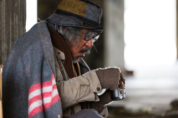 Elderly Homeless and hungry man eating food at abandoned building or on street