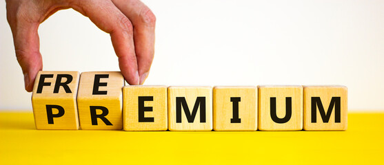 Premium or freemium symbol. Businessman turns wooden cubes and changes the word 'premium' to...