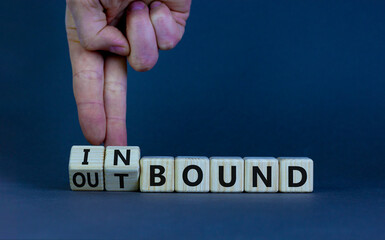 Inbound or outbound symbol. Businessman turns wooden cubes and changes the word 'outbound' to...