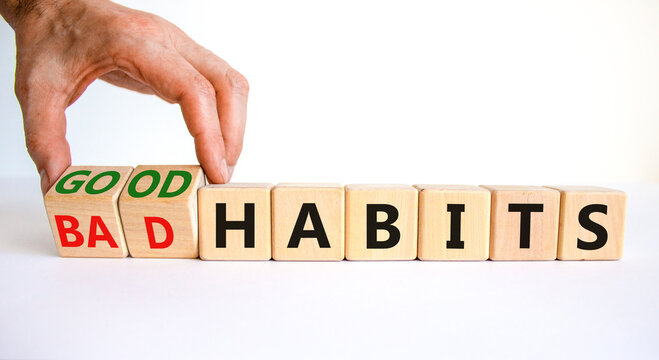 Good or bad habits symbol. Businessman turns wooden cubes and changes words 'bad habits' to 'good habits'. Beautiful white table, white background. Business, bad or good habits concept. Copy space.
