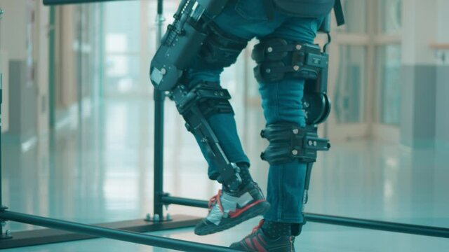Male patient is trying to walk in the exoskeleton