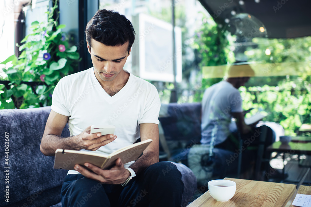 Poster intelligent male student with education notepad using 4g wireless for chatting and messaging via mob