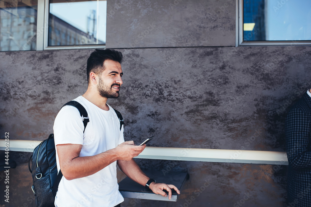 Poster side view of casual dressed male blogger with cellular technology for internet browsing thinking abo