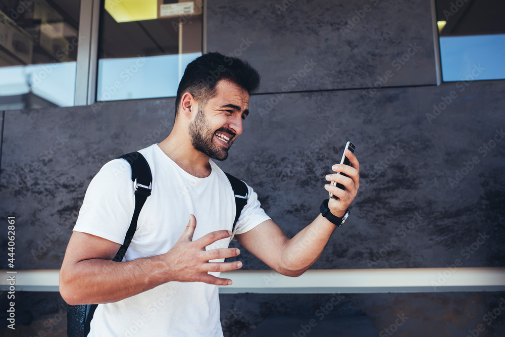 Poster caucasian tourist using wireless internet on modern mobile device for chatting and messaging with ne