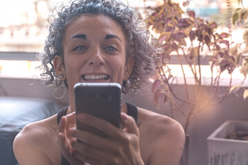 Short-haired girl smiling with her phone in her hand