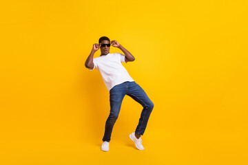 Fototapeta na wymiar Full length body size view of attractive funky guy dancing having fun touching specs isolated over bright yellow color background