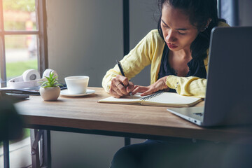 Female Hand of Planner writing daily appointment On 2021 Calendar book. Woman mark and note schedule (holiday trip) on diary at office desk. Calendar reminder Event for Planner concept.