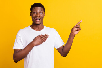 Photo of good brunet young guy point empty space wear white t-shirt isolated on yellow color background