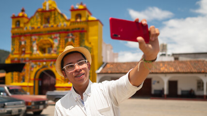 Portrait of a handsome young man taking a selfie in the park of San Andres Xecul, Guatemala.