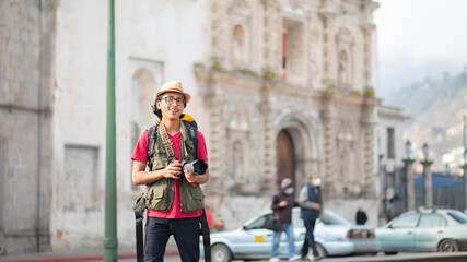 Portrait of a photographer with his camera in his hands and a church as a background.