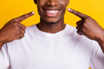 Cropped view portrait of attractive cheerful guy demonstrating white teeth isolated over vibrant yellow color background