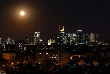 Beautiful view on  Frankfurt am Main (european finance center city) downtown skyline cityscape. Moon, supermoon during twilight blue hour, sunset, evening, night. Travel in Hesse. Hessen, Germany.