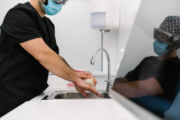 Doctor washing his hands in the hospital sink.
