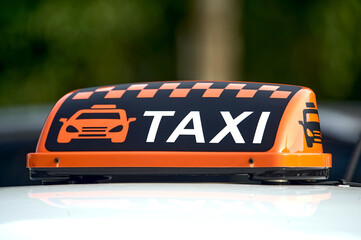 an orange taxi sign stands on the roof of the car
