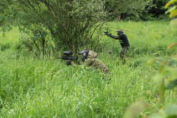 people shooting with paintball pistols