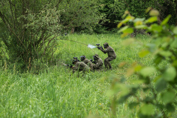 people shooting with paintball pistols
