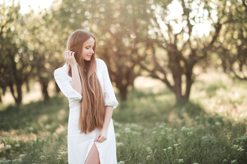 Beautiful young adult woman 29-30 year old with long blonde hair wear stylish white dress standing...