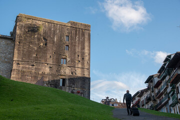 Parador de Hondarribia con un hombre con una maleta subiendo una cuesta. 