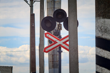 Railway traffic light on the background of the obelisk and blue sky